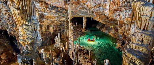 image d'une grotte avec des stalactites et des stalagmites et un point d'eau souterrain